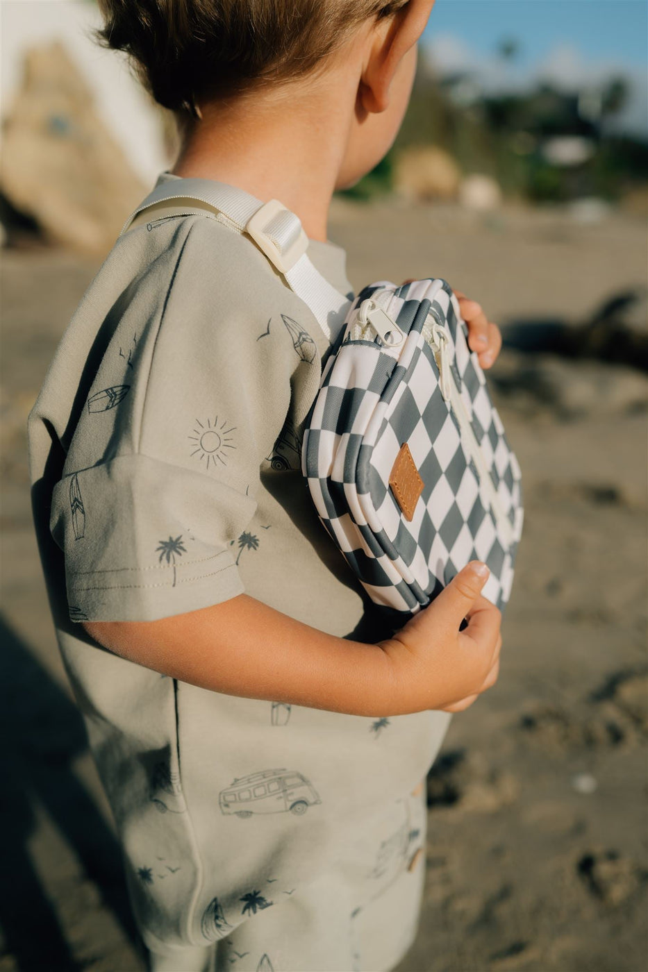 a child holding a checkered bag