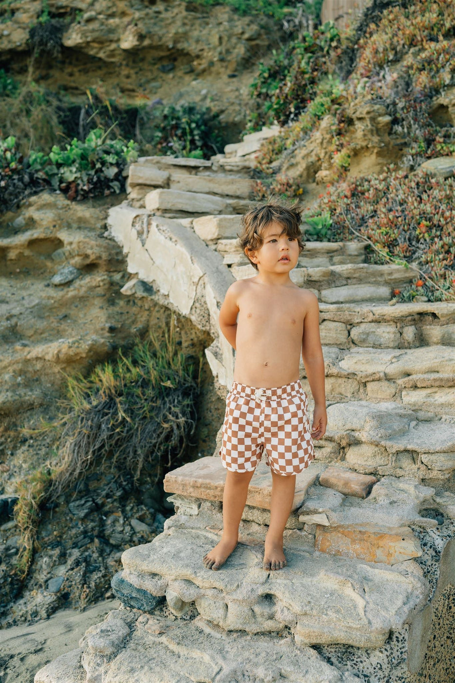 a boy standing on a stone staircase