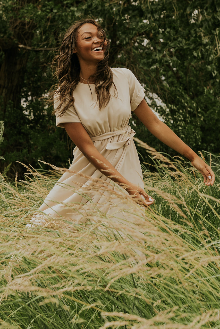 a woman in a dress in tall grass