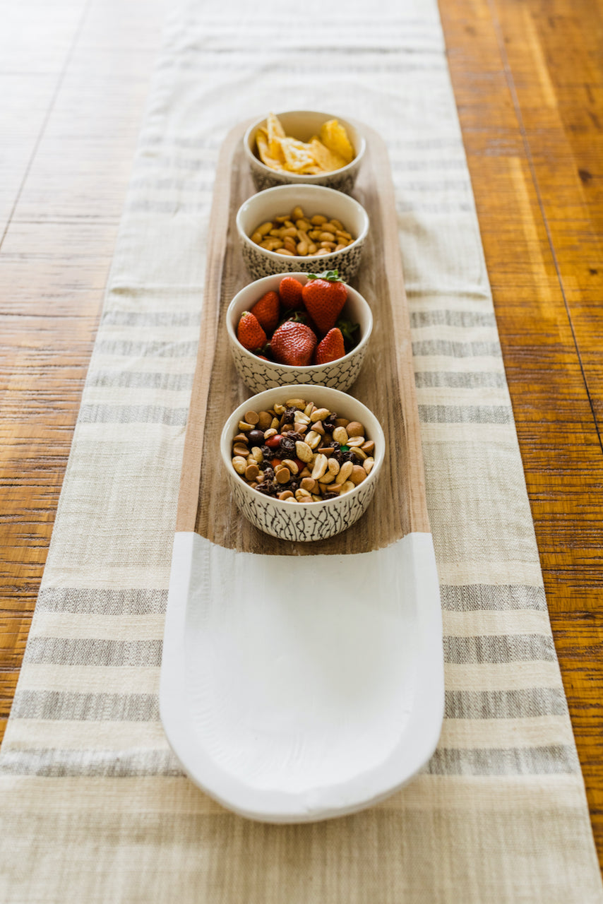 a row of bowls of nuts and fruits on a table