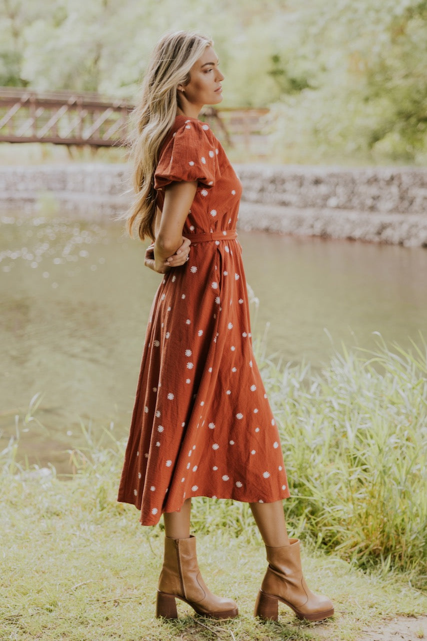 a woman in a dress by a river