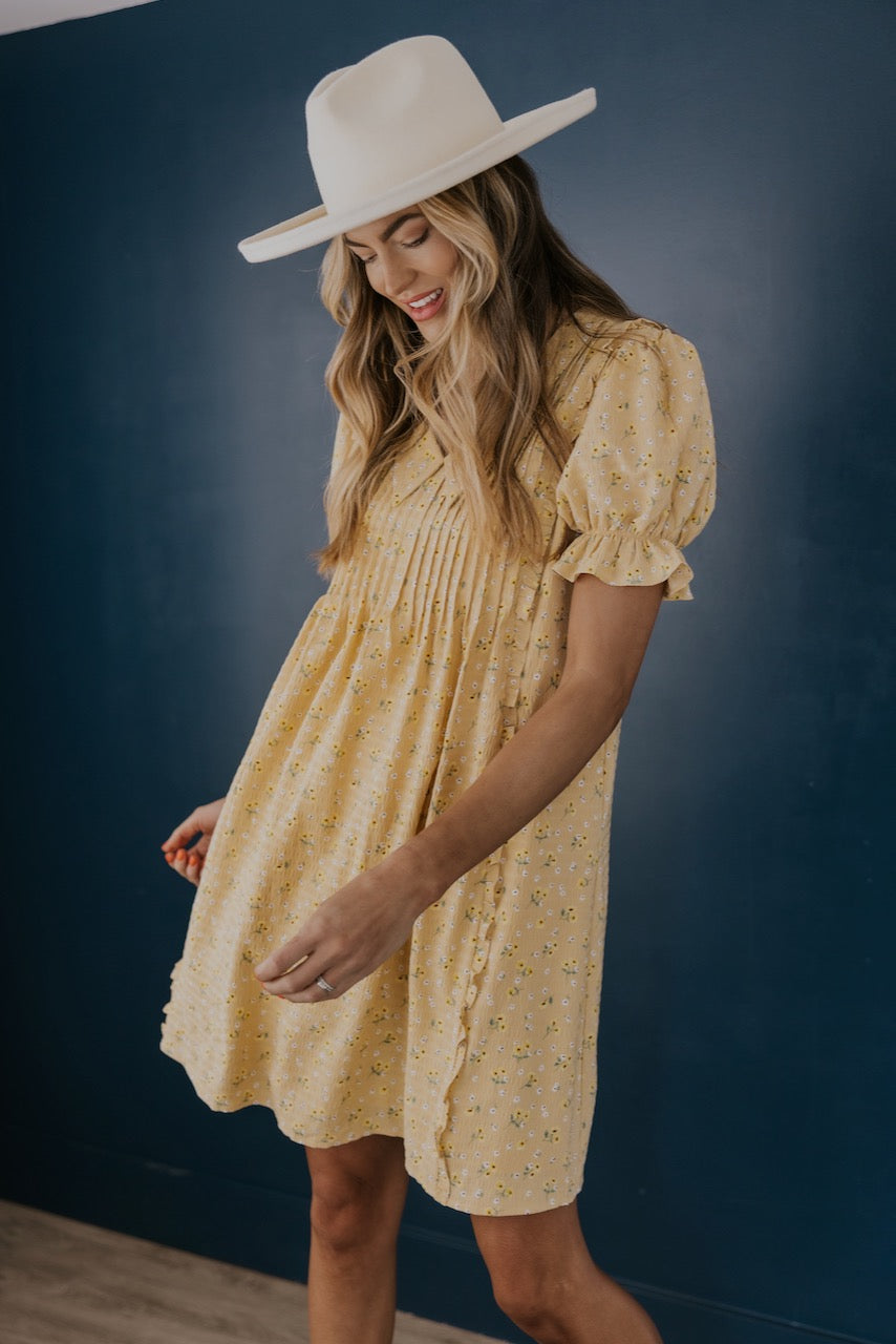 a woman wearing a yellow dress and hat