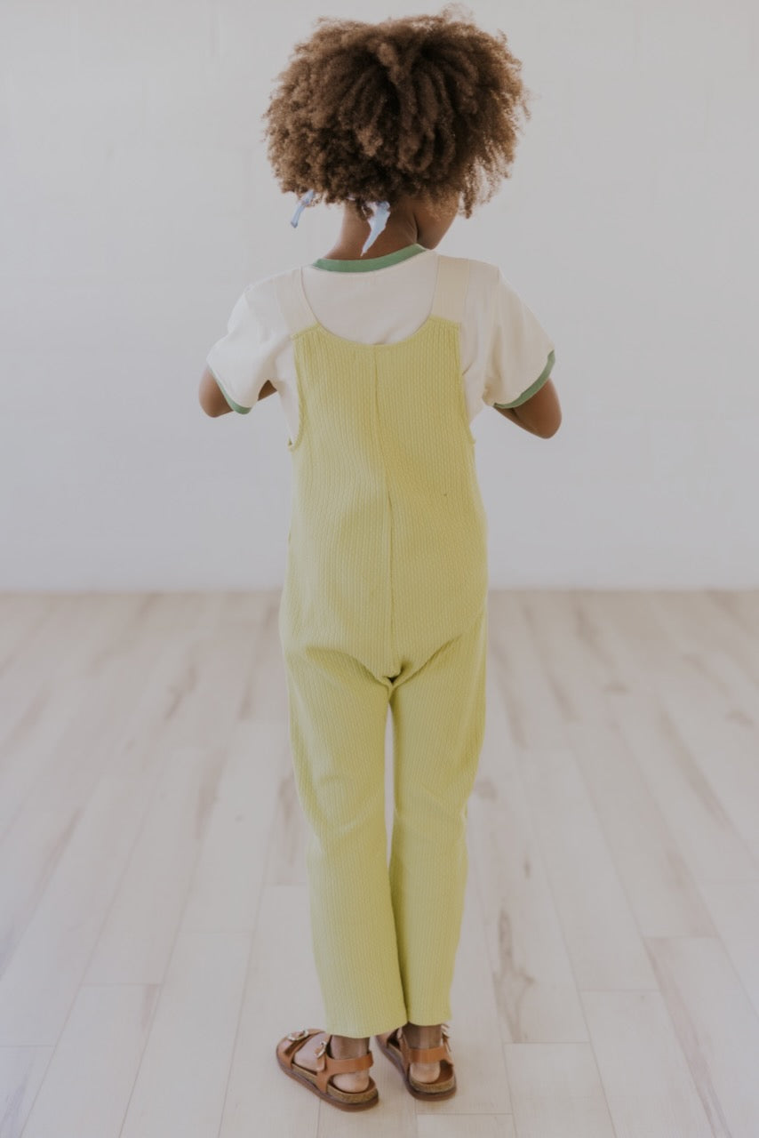 a child in yellow overalls