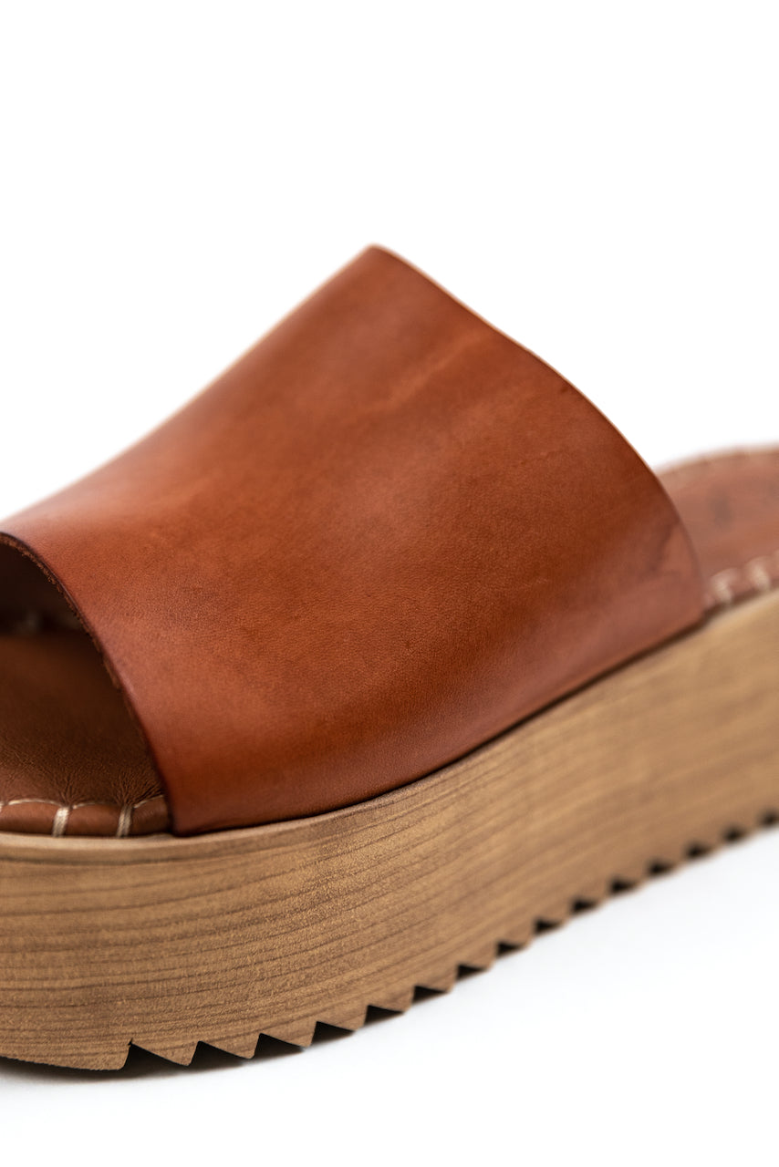 a brown leather sandal with a wooden platform